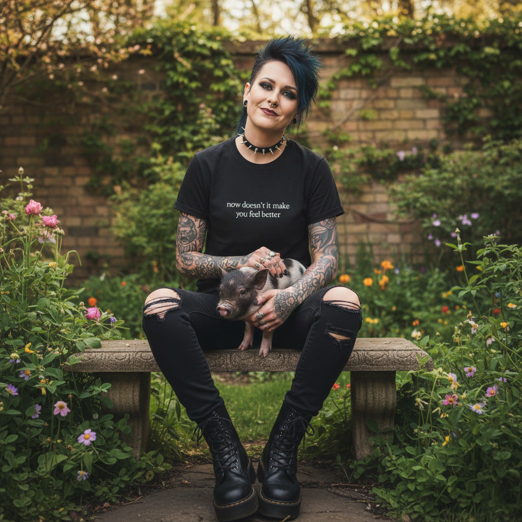 Elder goth wearing Now Doesn't It Make You Feel Better Shirt Nine Inch Nails Lyrics Comfort Colors Unisex T-Shirt in black while sitting in a flower garden with her pet pig