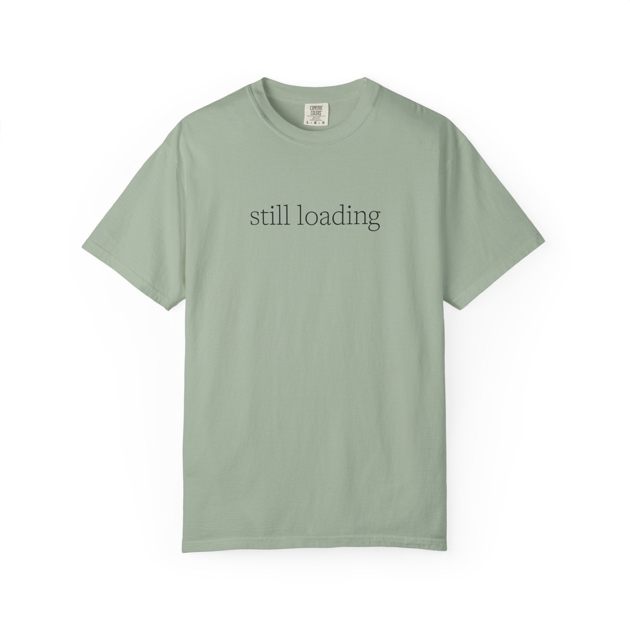 Light sage green t-shirt with 'still loading' text in white lettering