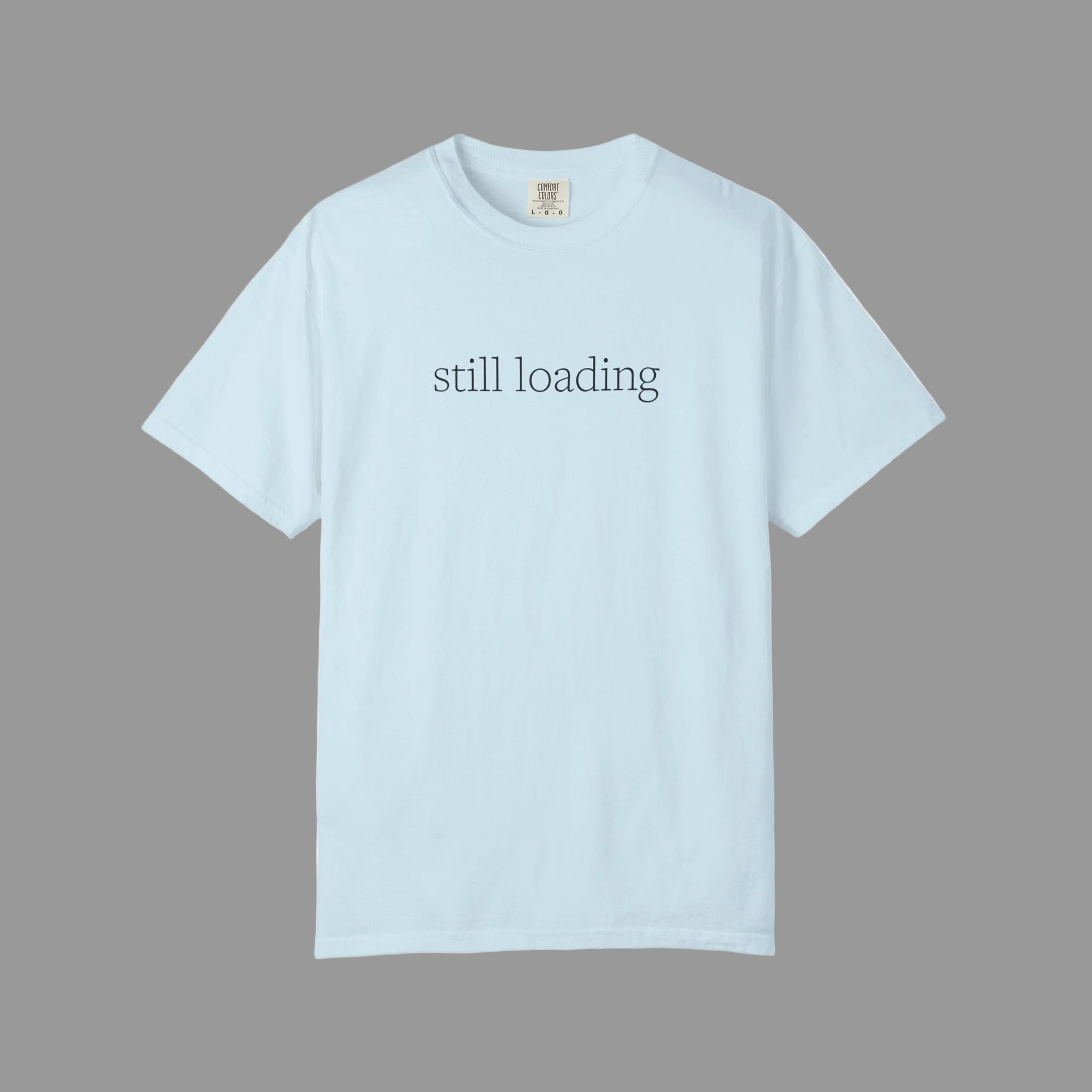Light blue t-shirt with 'still loading' text in black lettering