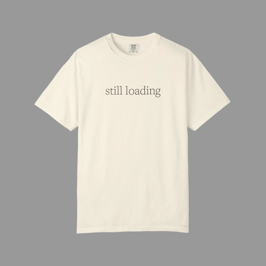 Beige t-shirt with 'still loading' text in espresso brown lettering